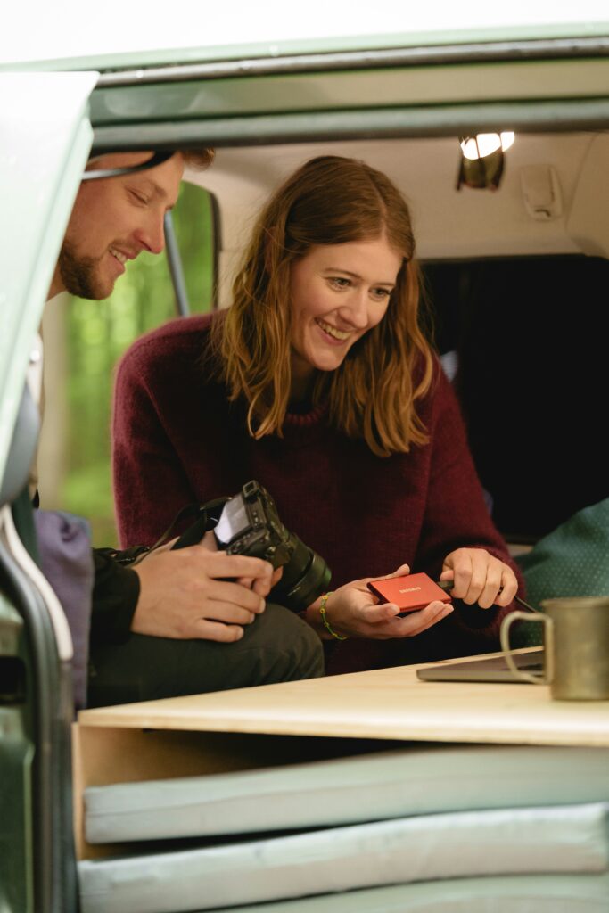 Van Life en couple auprès de la table centrale du van